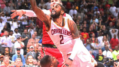 Cleveland Cavaliers guard Kyrie Irving gets called for a charge on a drive to the basket against the Atlanta Hawks’ Paul Millsap in overtime of Sunday’s game. (HENRY TAYLOR / HENRY.TAYLOR@AJC.COM)