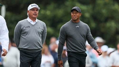 Fred Couples, left, and Tiger Woods talk as they walk down the second fairway after their tee shots during a practice round for the Masters golf tournament at Augusta National Golf Club in Augusta, Ga., Tuesday, April 9, 2024. (Jason Getz/Atlanta Journal-Constitution via AP)