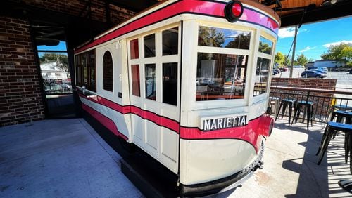 An antique trolley pokes out from the front facade of Marietta Square Market.