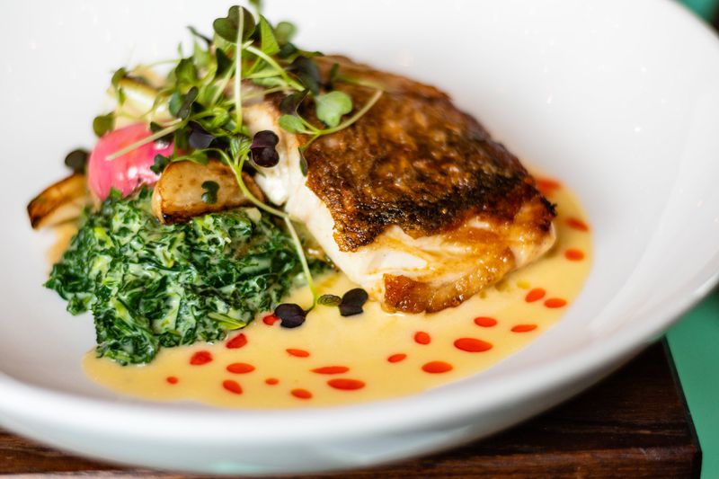 Here, it’s red snapper served with creamed kale and lemon beurre blanc at Watchman’s Seafood & Spirits. CONTRIBUTED BY HENRI HOLLIS