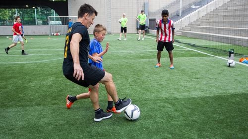 Phil Hill, executive director of Soccer in the Streets, mixes it up with kids at a summer camp at the Five Points MARTA Station. DAVE WILLIAMSON