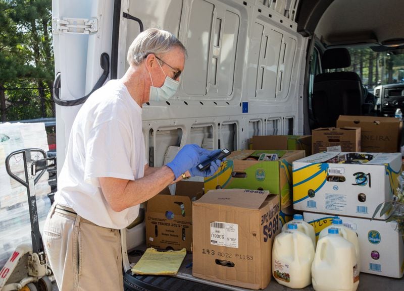 Ned Cone enters the weight into an app to keep track of donations given to Second Helping Atlanta. Food that is nearing its sell-by date is transported to the Atlanta Mission on Tuesday, June 2, 2020. (Jenni Girtman for The Atlanta Journal-Constitution)