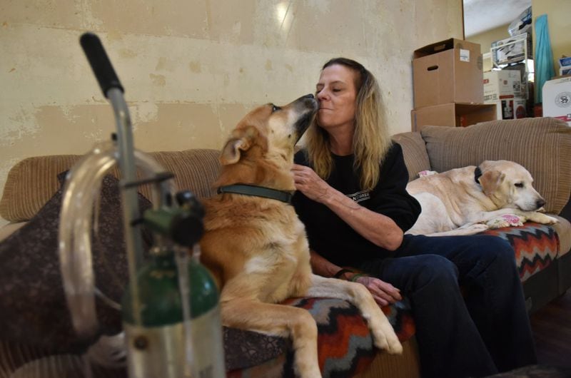 Mary Ann Statler plays with her dogs Bear (left) and Duke at her home, which was sold in foreclosure as she was battling for her Social Security benefit, on Wednesday, Dec. 13, 2017. Mary Ann Statler had battled depression and anxiety for years before her physician told her that her condition was so bad that she should not continue to work and that she should apply for disability benefits from Social Security. Since then, Statler has been caught in a backlog of more than 1 million disability cases nationwide. HYOSUB SHIN / HSHIN@AJC.COM