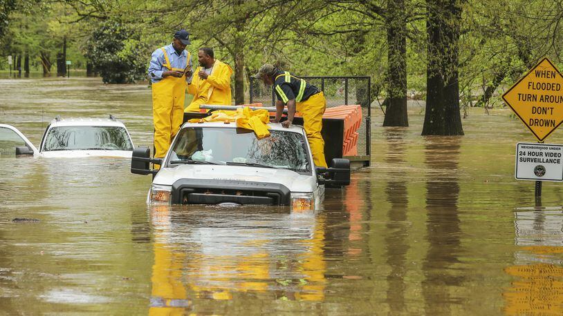 The Federal Reserve has fined SunTrust Banks $1.5 million for alleged violations of the National Flood Insurance Act. Here, metro Atlantans grappled with a flooded road after a storm in April. JOHN SPINK /JSPINK@AJC.COM