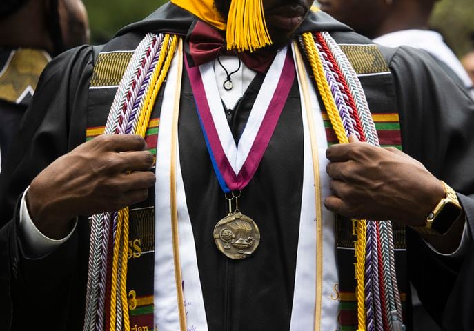 A Morehouse College graduate adjusts his robe during the Morehouse College commencement ceremony on Sunday, May 21, 2023, on Century Campus in Atlanta. The graduation marked Morehouse College's 139th commencement program. CHRISTINA MATACOTTA FOR THE ATLANTA JOURNAL-CONSTITUTION