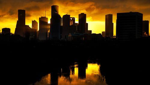 Sunlight streams between skyscrapers as the sunrise paints the sky behind downtown Tuesday, Feb. 21, 2017, in Houston.