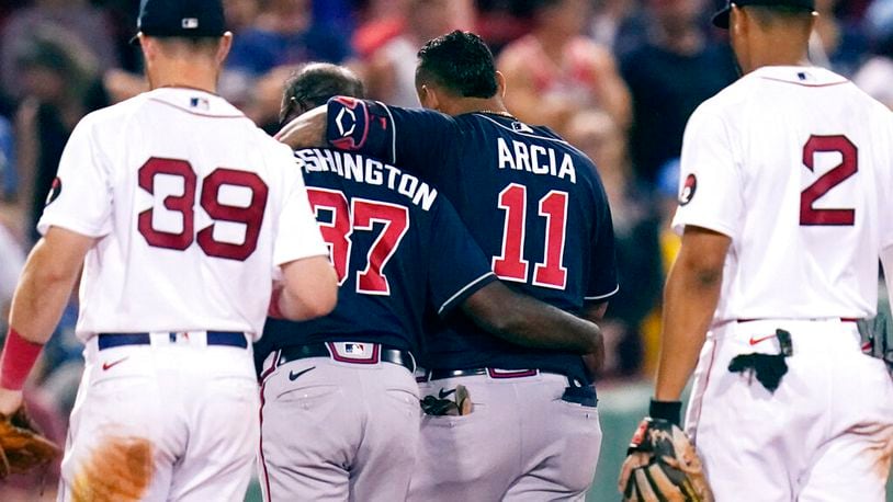 Atlanta Braves' Orlando Arcia (11) is helped from the field by third base coach Ron Washington (37), after an apparent injury, following an RBI single by Arcia, which broke a 6-6 tie, during the tenth inning of a baseball game against the Boston Red Sox, Tuesday, Aug. 9, 2022, in Boston. (AP Photo/Charles Krupa)