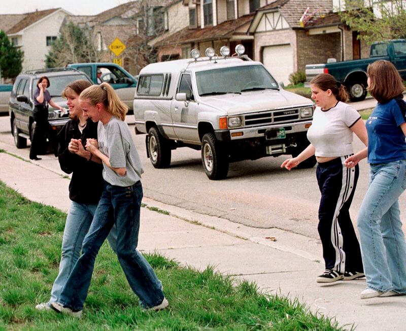 FILE - Students from Columbine High School are led away from the facility after two gunmen went on a shooting rampage, in the southwest Denver suburb of Littleton, Colo., April 20, 1999. Twenty-five years later, The Associated Press is republishing this story about the attack, the product of reporting from more than a dozen AP journalists who conducted interviews in the hours after it happened. The article first appeared on April 22, 1999. (AP Photo/David Zalubowski, File)