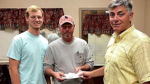 Brantley Wommack (left) and his father Mark received a $5,500 reward Tuesday from Walton County Sheriff Joe Chapman for leading deputies to an accused killer.