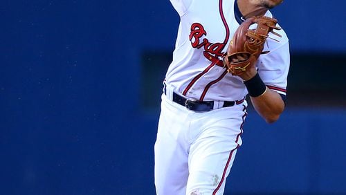 Braves shortstop Andrelton Simmons knocks down a hard hit ball by Cardinals Yadier Molina and throw to first during their MLB game on Monday, May 5, 2014, in Atlanta.