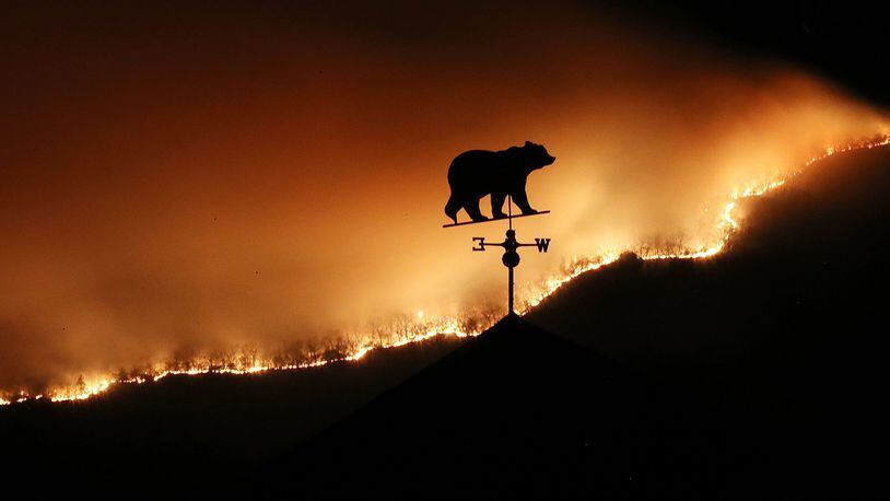 November 21, 2016, Clayton: At first glance the weathervane on the top of a barn appears to be a bear fleeing the Rock Mountain Fire as it burns across the top of ridge pole above Bettyâ€™s Creek Road where home owners are under a pre-evacuation order as the fire approaches the area on Monday night, Nov. 21, 2016, just north of Clayton. Curtis Compton/ccompton@ajc.com