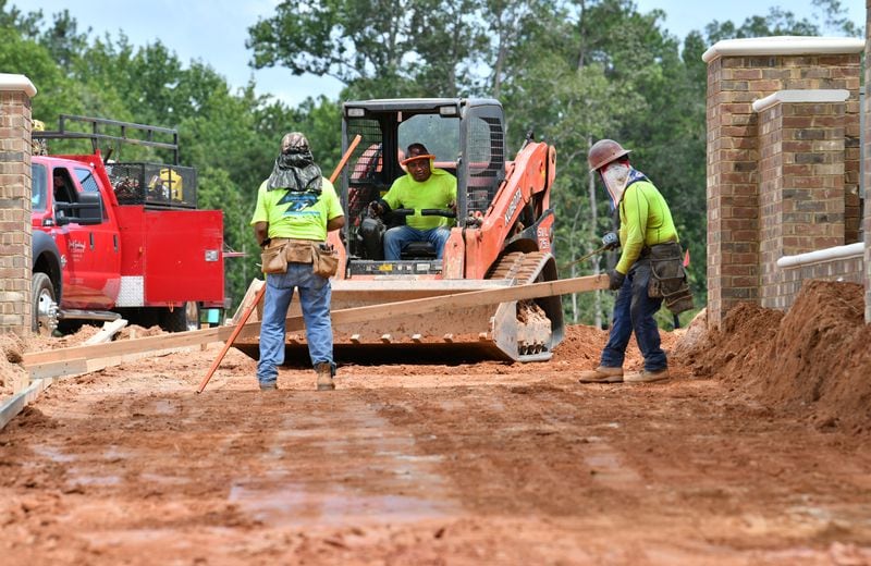 Construction crews work at a construction site for Atley homes and a section of the Alpha Loop in Alpharetta. The Alpha Loop is a multi-use trail system connecting the downtown district, Avalon and Northwinds office development. (Hyosub Shin / Hyosub.Shin@ajc.com)