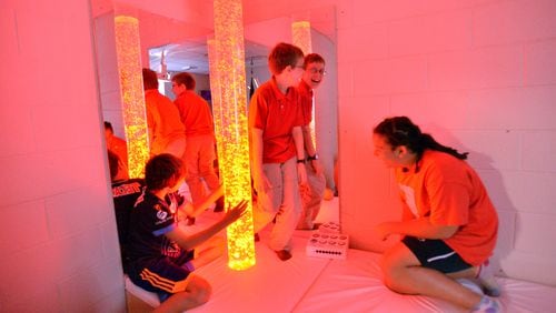 Sixth-grade students (from left) Aidan Hurtado, Jason Heath and Gabriela Coty, all 11, use the calm room with relaxing chairs, a music system and a multicolored bubble light at Tapestry Public Charter School.