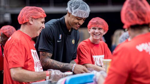 Atlanta Hawks player John Collins helps pack food with volunteers during the event to pack 1 million meals at State Farm Arena on Saturday, Oct. 5, 2019, in Atlanta. BRANDEN CAMP/SPECIAL TO THE AJC