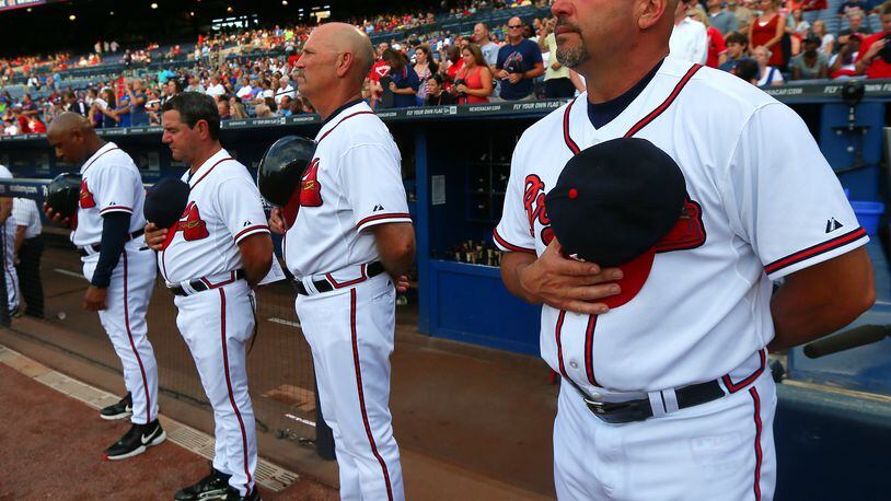 Atlanta Braves manager Fredi Gonzalez (from right to left), coaches Brian Snitker, Carlos Tosca, Terry Pendleton, players and fans observe a moment of silence for Ronald Lee Homer, 30, of Conyers, who fell to his death before the start of their game against the Phillies at Turner Field on Tuesday, August 13, 2013, in Atlanta. CURTIS COMPTON / CCOMPTON@AJC.COM
