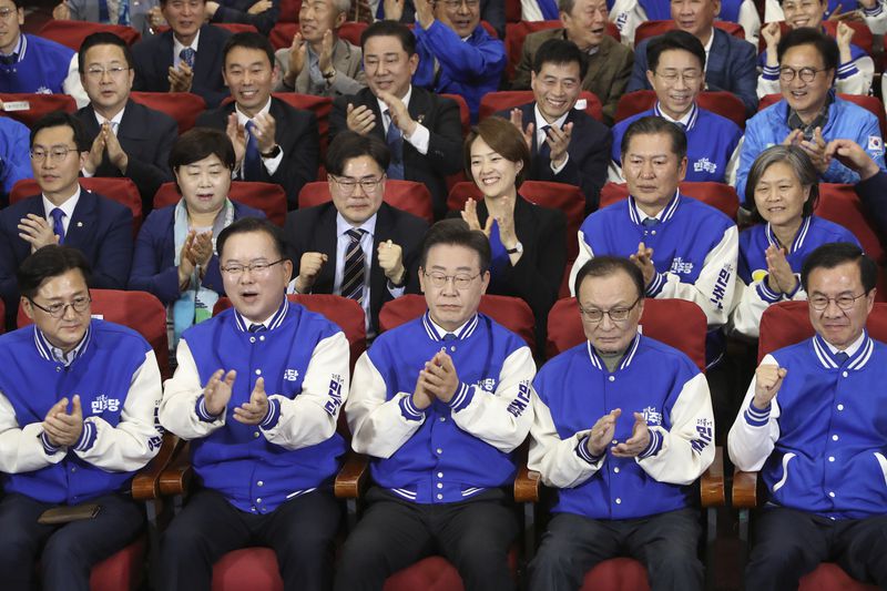 South Korea's main opposition Democratic Party (DP) leader Lee Jae-myung, center, and candidates, watch TV broadcasting results of exit polls for the parliamentary election at the National Assembly on Wednesday, April 10, 2024 in Seoul, South Korea. (Chung Sung-Jun/Pool Photos via AP)
