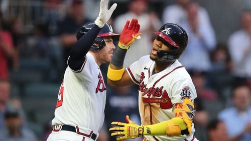 Braves outfielder Ronald Acuna is congratulated by teammate Freddie Freeman as he crosses home plate after hitting a solo home run against the Toronto Blue Jays during the third inning Tuesday, May 11, 2021, in Atlanta. (Curtis Compton / Curtis.Compton@ajc.com)