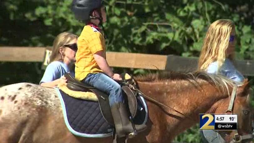 Charlie, a 5-year-old with special needs, rides a horse at Rising Hope Farm on Tuesday. The farm is part of Special Equestrians of Georgia.
