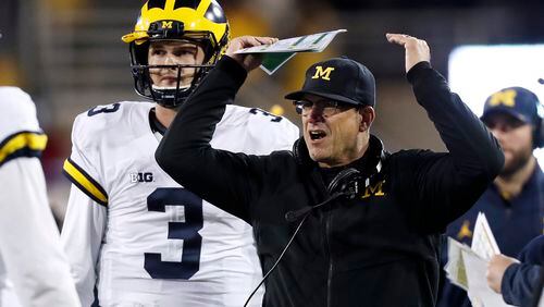 An upsetting weekend all around for college football: Here Michigan coach Jim Harbaugh reacts to a call during the second half against Iowa, (AP Photo/Charlie Neibergall)