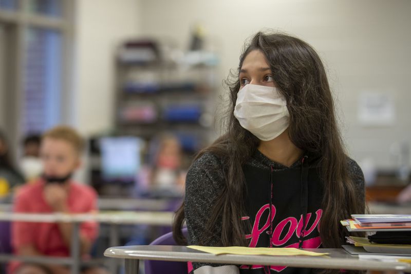 A Cartersville Middle School student wears a face mask while participating in Spanish class on the third day of school, Aug. 20, 2020. The school experimented with a hybrid model, combining social distancing for in-person classrooms with online learning for students at home. (ALYSSA POINTER / ALYSSA.POINTER@AJC.COM)