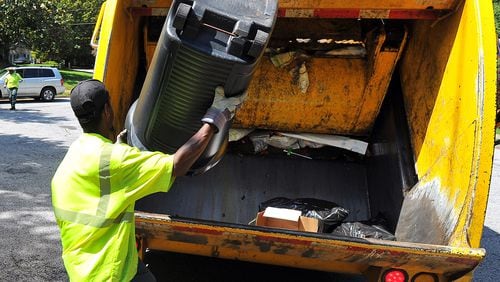 DeKalb County sanitation worker Larry Wyatt dumps trash into the truck.