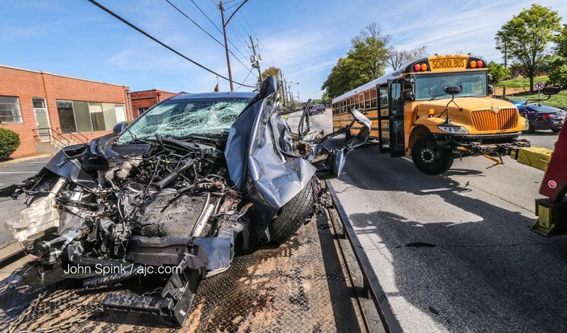 An Atlanta Public Schools bus was involved in a five-vehicle crash Wednesday morning, trapping a woman inside a Mazda and blocking multiple lanes on Northside Drive for hours.