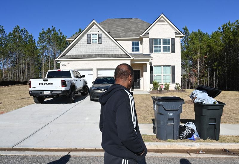 Pernell Evans, homeowner at Parkview Estates in South Fulton, walks by a smaller and lower quality home for rent (background) in his neighborhood. Hyosub Shin / Hyosub.Shin@ajc.com