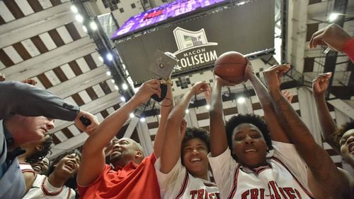 March 10, 2022 Macon - Tri-Cities' head coach Omari Forts and players celebrate their victory over Eagle's Landing during the 2022 GHSA State Basketball Class AAAAA Boys Championship game at the Macon Centreplex in Macon on Thursday, March 10, 2022. Tri-Cities won 67-59 over Eagle's Landing. (Hyosub Shin / Hyosub.Shin@ajc.com)