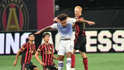 August 29, 2020 Atlanta - Orlando City midfielder Junior Urso (11) and Atlanta United defender Jeff Larentowicz (18) battle for the ball  during the second half in a MLS soccer match at Mercedes-Benz Stadium in Atlanta on Saturday, August 29, 2020. Orlando City won 3-1 over the Atlanta United. (Hyosub Shin / Hyosub.Shin@ajc.com)