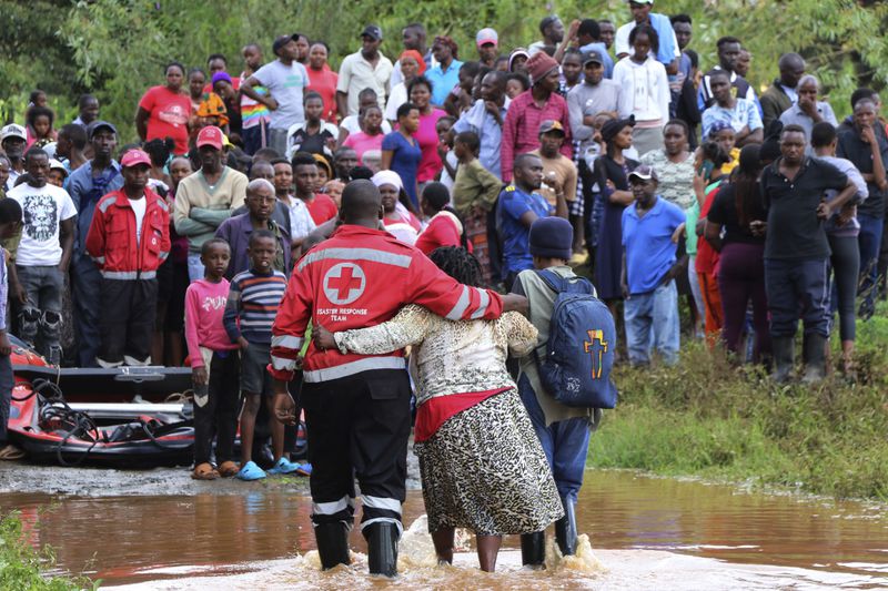 FILE - A woman is rescued from her flooded house by Red Cross workers in Githurai area of Nairobi, Kenya, April 24, 2024. (AP Photo/Edaward Odero, File)