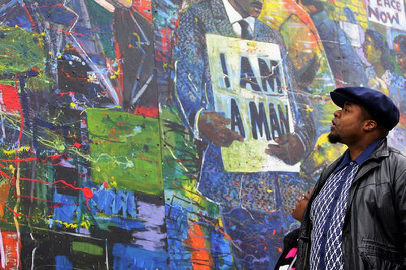 Reinard McGruder (right) and his daughter, Gianna, look over the mural. Across 25 5-by-10-foot steel panels, Delsarte chronicles the entwined story of King and the civil rights movement, from the assassination of Emmett Till to Bull Connor's attacking police dogs. The mural is populated by dozens of faces, from Rosa Parks to Bobby Kennedy and Malcolm X to Nina Simone.