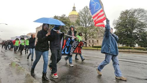 Carol Jones an advocacy specialist from the Shepherd Center carries a disability flag as she joined disability advocates and supporters who gathered in the rain at Liberty Plaza for the 17th Annual Disability Day for a State of Georgia Capitol rally hosted by the Georgia Council on Developmental Disabilities (GCDD) on Thursday, March 5, 2015. Advocates from across the state join together for support of legislation that will promote the independence, inclusion, productivity and self-determination of people with disabilities.
