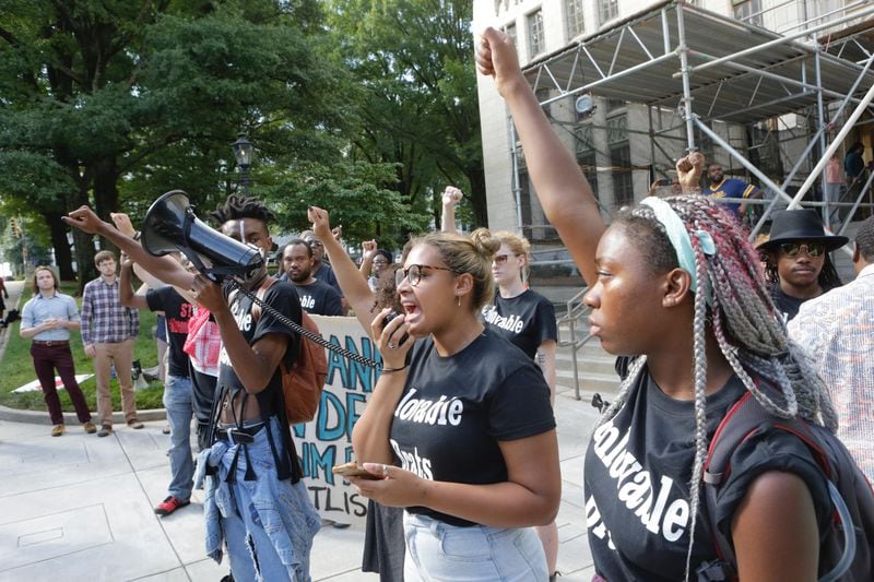 Black Lives Matter protesters, wearing "Unlovable Brats" t-shirts, rally outside of Atlanta City Hall downtown on July 16, 2014. The t-shirts are a reference to comments made by former Atlanta mayor Andrew Young, who said “Those are some unlovable little brats out there some times” in an earlier July meeting with officers at a southwest Atlanta precinct. Young has since apologized for the statement.