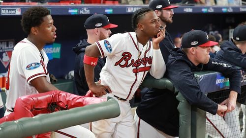 Ronald Acuna and Ozzie Albies watch from the dugout as the Dodgers celebrate their 6-2 victory over the Braves Monday at SunTrust Park. (Curtis Compton/ccompton@ajc.com)
