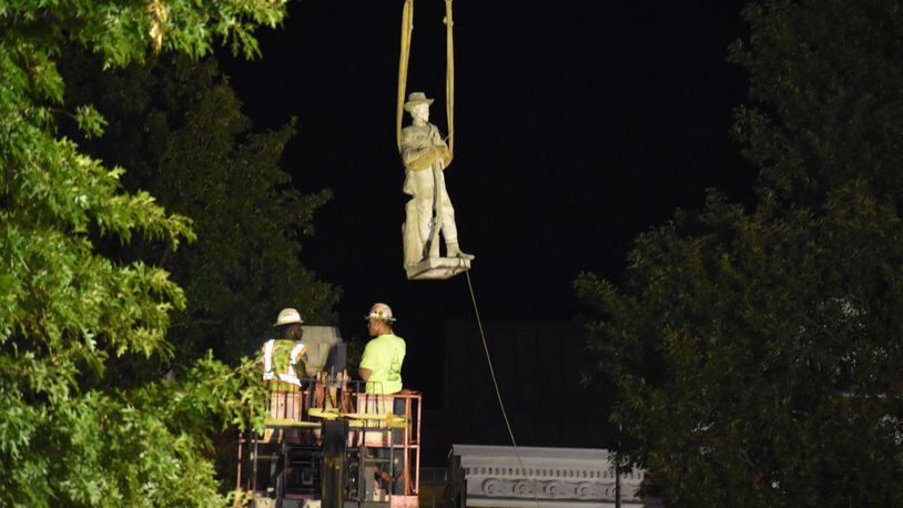 Crews remove a statue of Confederate soldier Charles T. Zachry from atop a monument in the McDonough Square on July 28. LEON STAFFORD / AJC