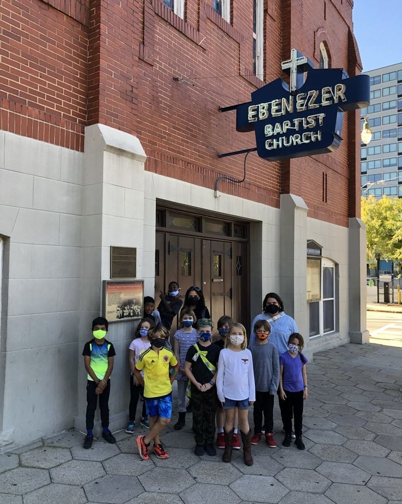 A school group visiting the original Ebenezer Baptist Church poses under a neon sign that is instantly associated with Atlanta. Photo: David Y. Mitchell