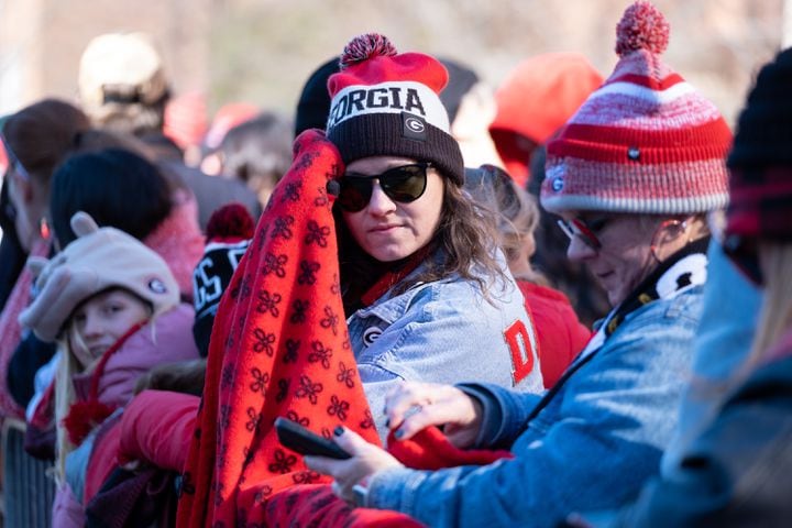 Kyrie Patton tries to stay warm while waiting for the start of the Dawg Walk before the UGA football celebration Saturday, Jan. 14, 2023 in Athens. Ben Gray for the Atlanta Journal-Constitution