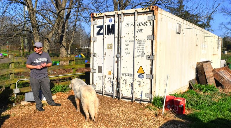 Shaun Terry, owner of Grateful Pastures in Mansfield, stands in front of a modified and insulated shipping container used as the brooder, the area where the baby chicks live until they're ready to go to the pasture enclosures. Chris Hunt for The Atlanta Journal-Constitution