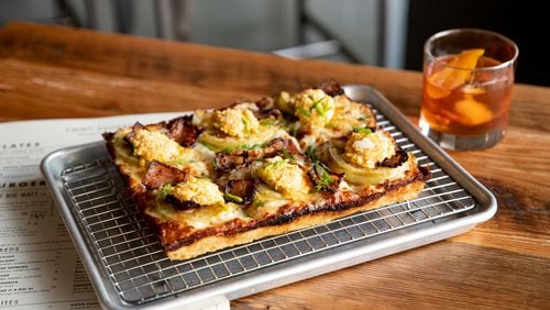 Emmy Squared Pizza has plenty of creative options, including the Shed pie (green tomato, green onion, bacon jam, pimento cheese). It's shown here with the Out of Fashion cocktail. (Mia Yakel for The Atlanta Journal-Constitution)