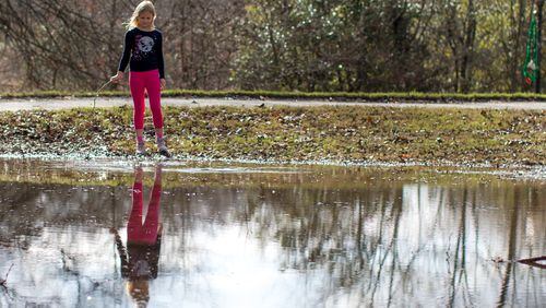 Teresa, 8, plays near a puddle of water in Piedmont Park on Tuesday, Dec. 29, 2015, in Atlanta. BRANDEN CAMP/SPECIAL
