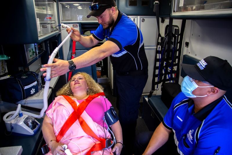 Central Paramedics Brandon Kindland, center, and and Tee Tyrrell, right, demonstrate how they would use an Airvo 2, a high oxygen nasal cannula, on Chief Nursing Officer Daihan Underwood at their Roswell facilities. (Steve Schaefer for The Atlanta Journal-Constitution)