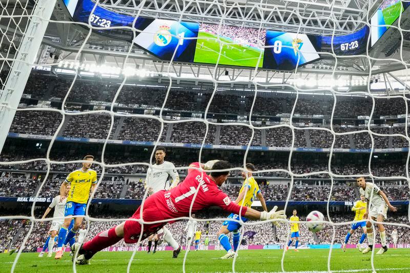 Real Madrid's Jude Bellingham, second left, scores his side's second goal during the the Spanish La Liga soccer match between Real Madrid and Cadiz at the Santiago Bernabeu stadium in Madrid, Spain, Saturday, May 4, 2024. (AP Photo/Manu Fernandez)