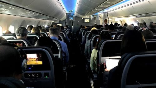 Main cabin passengers pass the time aboard American Airlines flight 2331, a Boeing 787-800 Dreamliner, an route from Chicago O’Hare International Airport to Dallas/Fort Worth International Airport, on March 5, 2018. (Jerome Adamstein/Los Angeles Times/TNS)