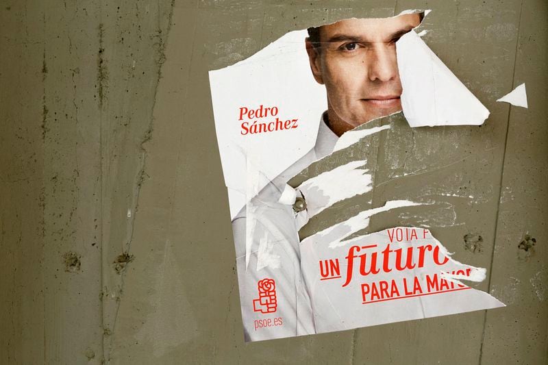FILE - A poster of the leader of Socialist Party Pedro Sanchez is ripped out in Madrid, Dec. 16, 2015. Spain is in nail-biting suspense Monday as it waits for Prime Minister Pedro Sanchez to announce whether he will continue in office or not. Sanchez, 52, shocked the country on Thursday, announcing he was taking five days off to think about his future after a court opened preliminary proceedings against his wife on corruption allegations. (AP Photo/Daniel Ochoa de Olza, File)
