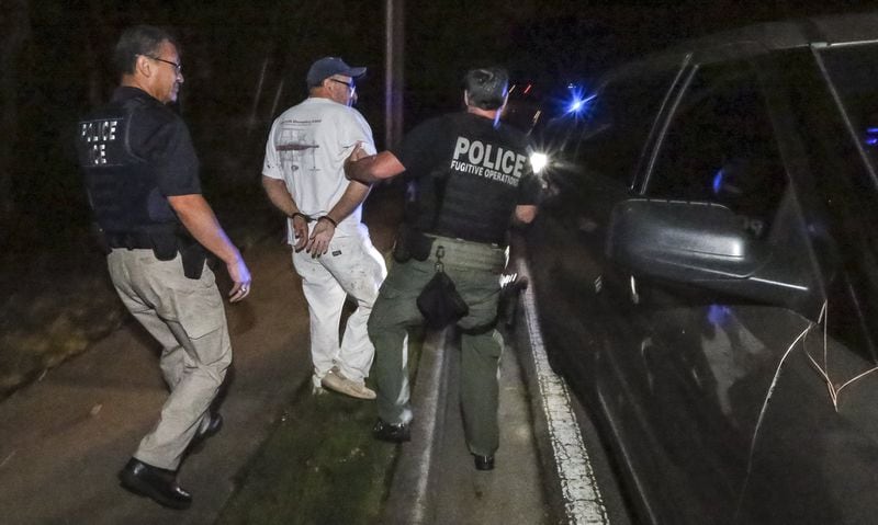 U.S. Immigration and Customs Enforcement (ICE) in action in metro Atlanta: ICE Atlanta deputy field office director Joe Sifuentez (left) and an unidentified ICE agent (right) take José Serrano into custody on Aug. 18, 2017, in Austell. JOHN SPINK/JSPINK@AJC.COM