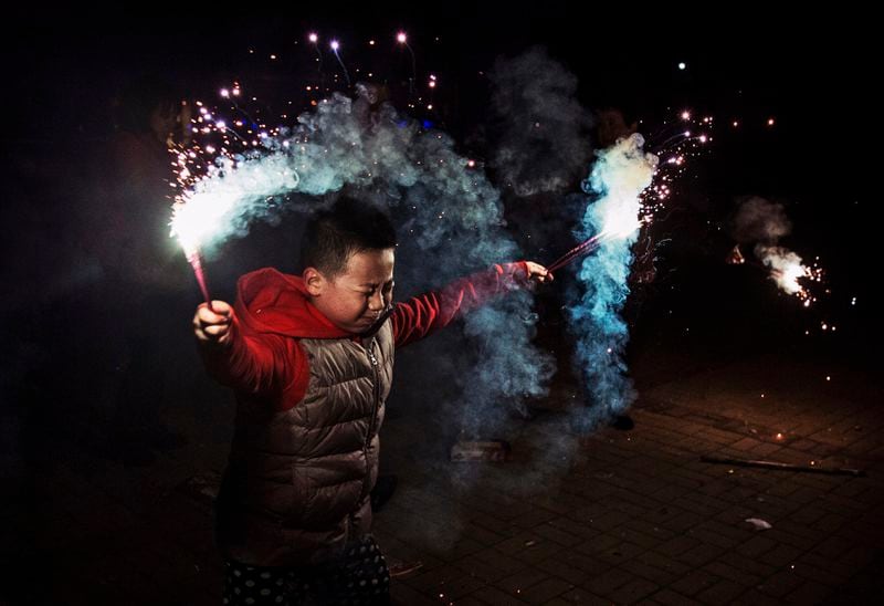 A boy uses sparklers during celebrations of the Lunar New early on February 19, 2015 in Beijing, China.