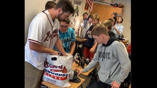 Chad Sobotka, Braves pitcher, hands out shirts and hats to the baseball team at Campbell High School in Smyrna.
