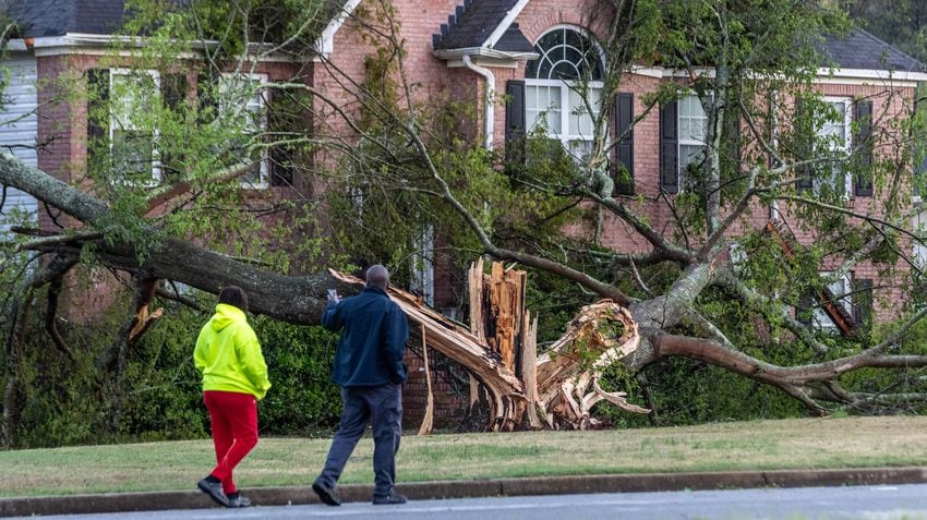 Greg and Lisa Daniels survey storm damage Wednesday, April 3, 2024, on Woverton Court in Rockdale County. (John Spink / John.Spink@ajc.com)