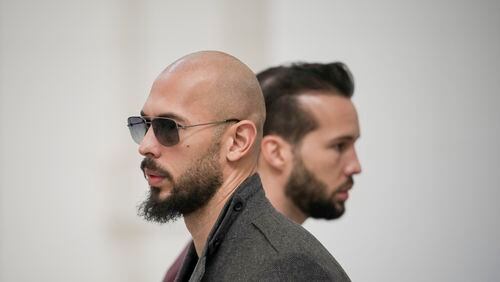 FILE - Andrew Tate, left, and his brother Tristan, right, wait inside the Court of Appeals building in Bucharest, Romania, Tuesday, Jan. 30, 2024. A court in Romania's capital on Friday, April 26, 2024, ruled that a trial can start in the case of influencer Andrew Tate, who is charged with human trafficking, rape and forming a criminal gang to sexually exploit women.(AP Photo/Vadim Ghirda, File)