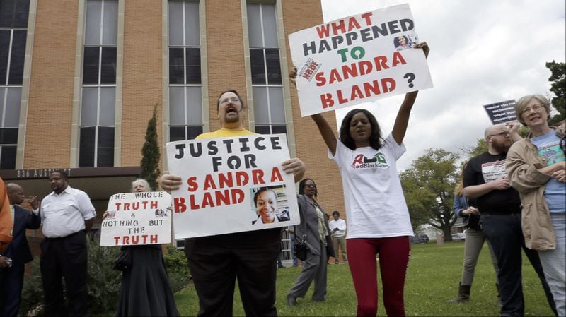 Demonstrators are pictured outside the Waller County Courthouse March 22, 2016, in Hempstead, Texas, during former Texas state Trooper Brian Encinia's arraignment on a perjury charge in the July 10, 2015, arrest of Sandra Bland. Encinia, then 30, pulled Bland over for failing to signal a lane change, a traffic stop that ended with her arrest on a charge of assaulting a public servant. Bland, 28, was found hanging in her jail cell at the Waller County Jail three days later. Bland, whose family sued state and county officials over her arrest and subsequent death, became a prominent face of the Black Lives Matter movement after she died in police custody. Encinia was fired, but his perjury charge was later dropped in exchange for his never seeking another law enforcement job.